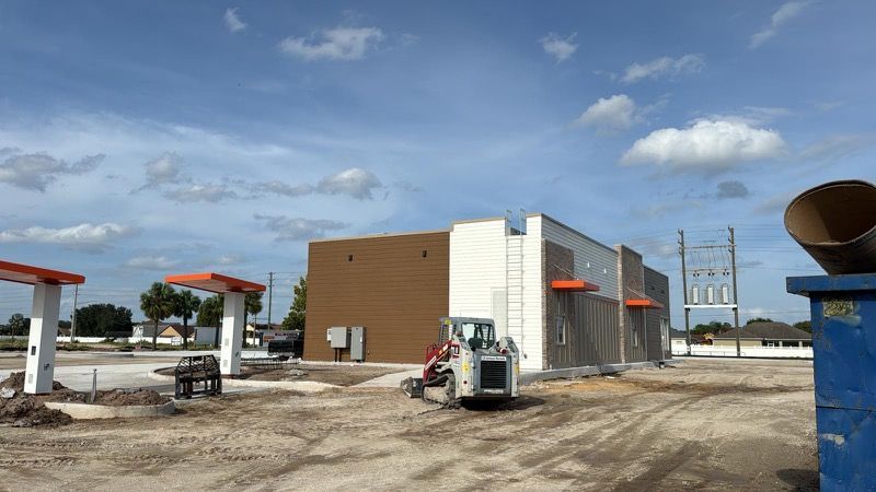A construction vehicle is parked in front of a building under construction.