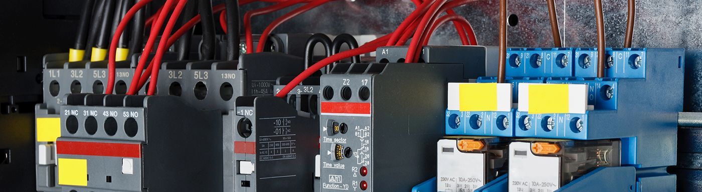 A close up of a electrical panel with a lot of wires coming out of it.