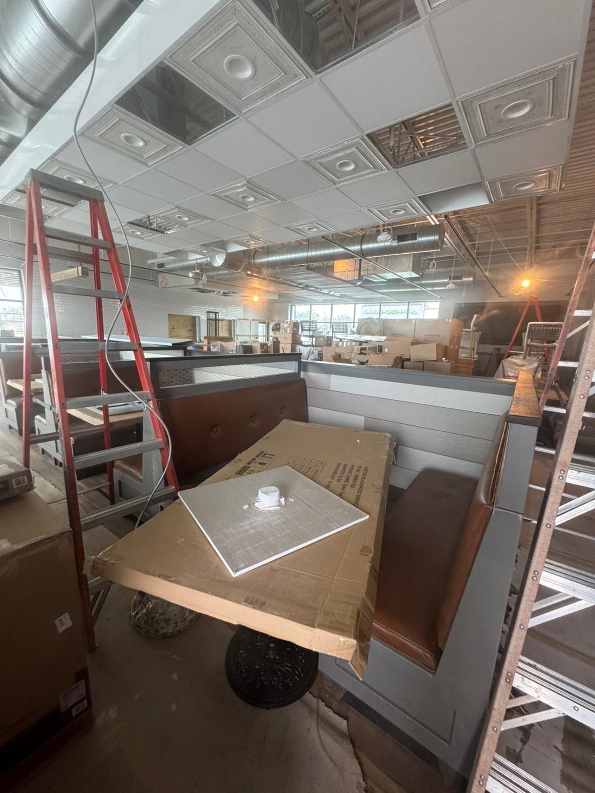 A restaurant is being remodeled and a table is sitting in the middle of the room.