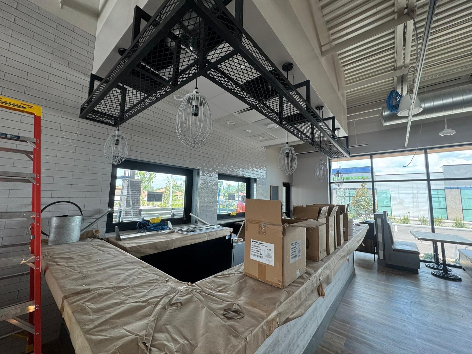 An empty restaurant with a bar and boxes on the counter.