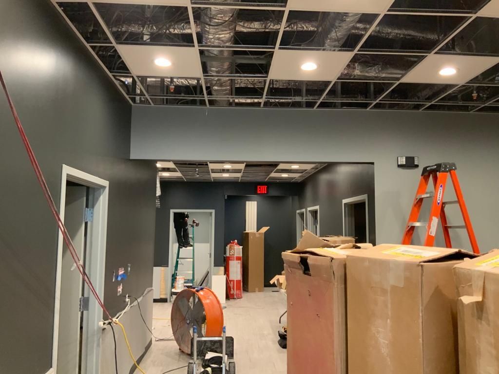 A room that is being remodeled with boxes and a ladder.