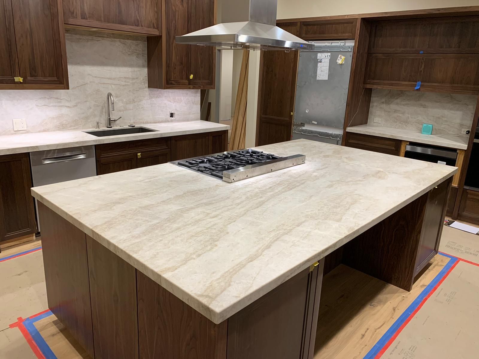 A kitchen with a large island and a stove top oven.