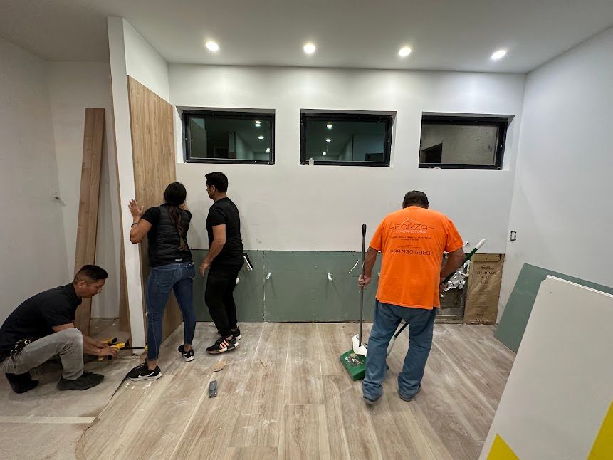 A group of people are working on a wall in a room.