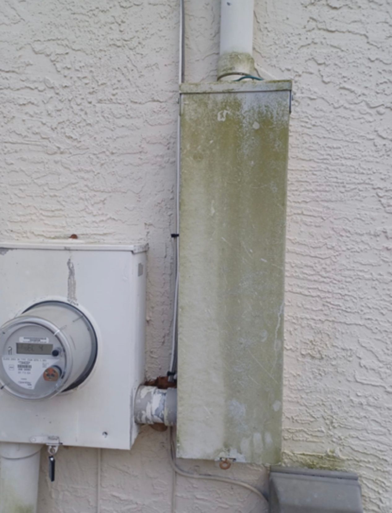 There is a meter on the side of a building.
