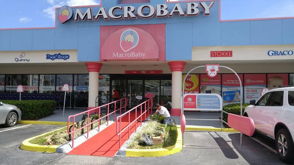 A car is parked in front of a store called macrobaby