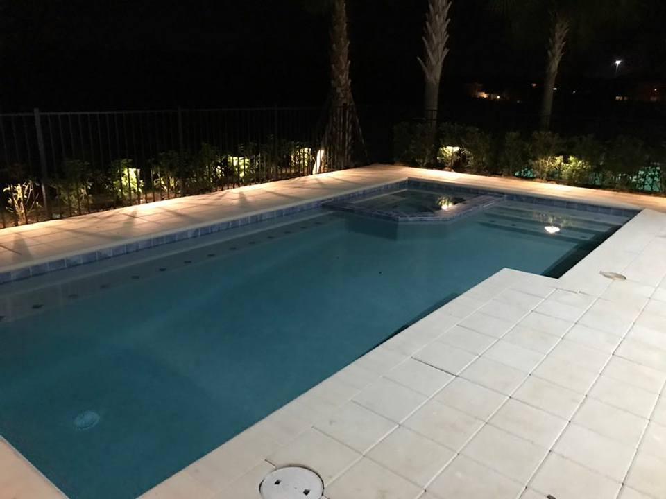 A large swimming pool is lit up at night