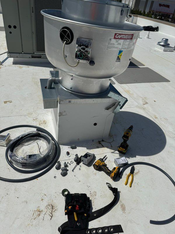 A machine is being repaired on the roof of a building.