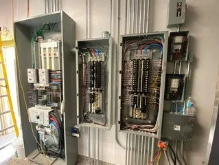 Three electrical boxes are sitting next to each other on a wall.