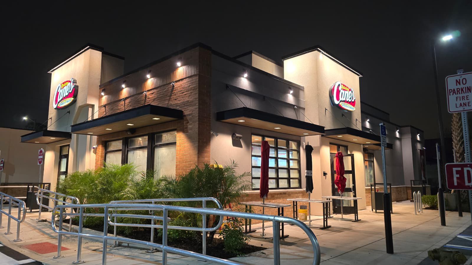 Exterior of an Eddy's restaurant at night, beige and brick facade, illuminated signage, ramp, and closed windows.
