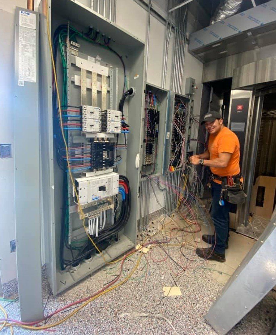 A man is working on a electrical panel in a building.