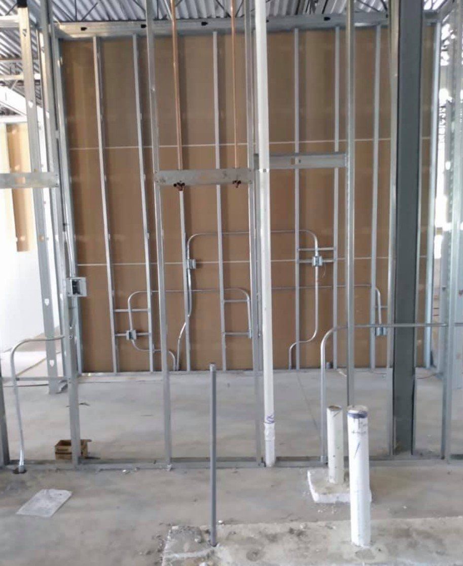 A building under construction with pipes coming out of the wall