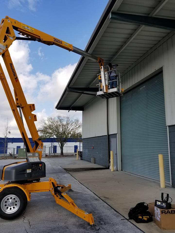 A man is working on the roof of a building with a crane.