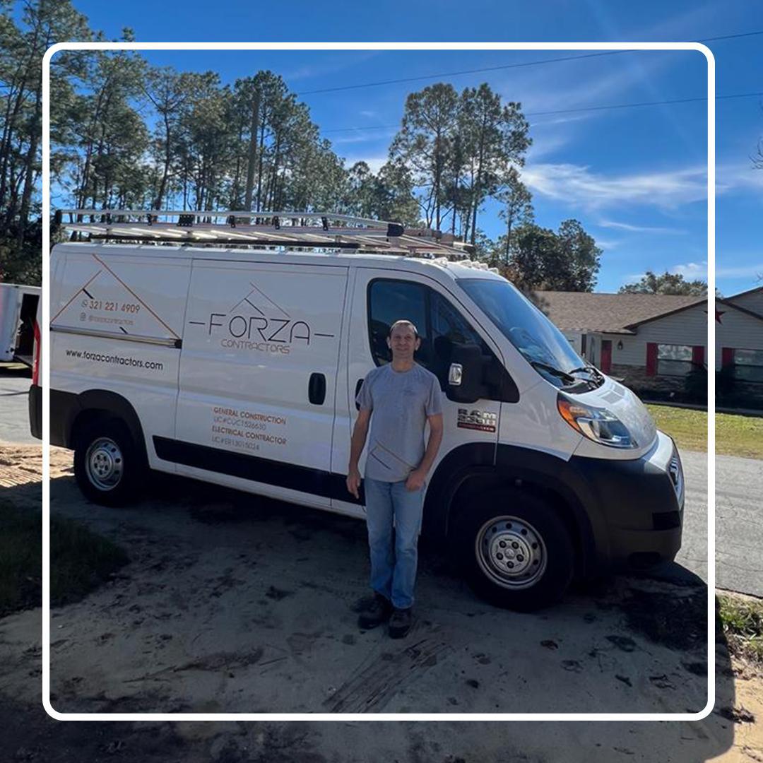A man is standing in front of a white van.