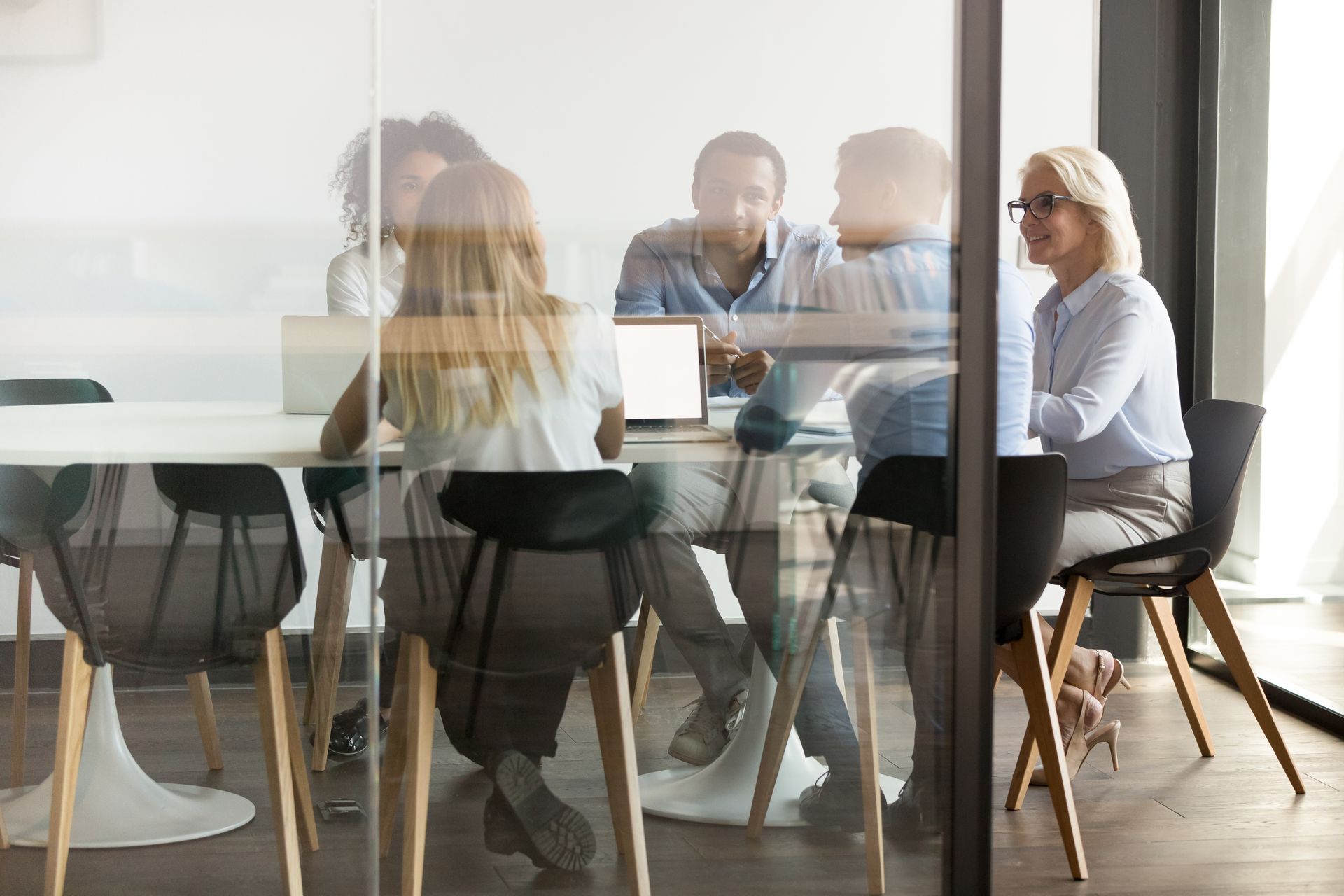 A group of people are sitting around a table in a conference room.