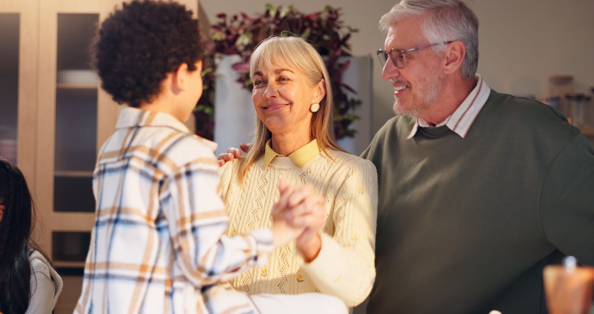 Three people chatting and smiling indoors at a casual gathering