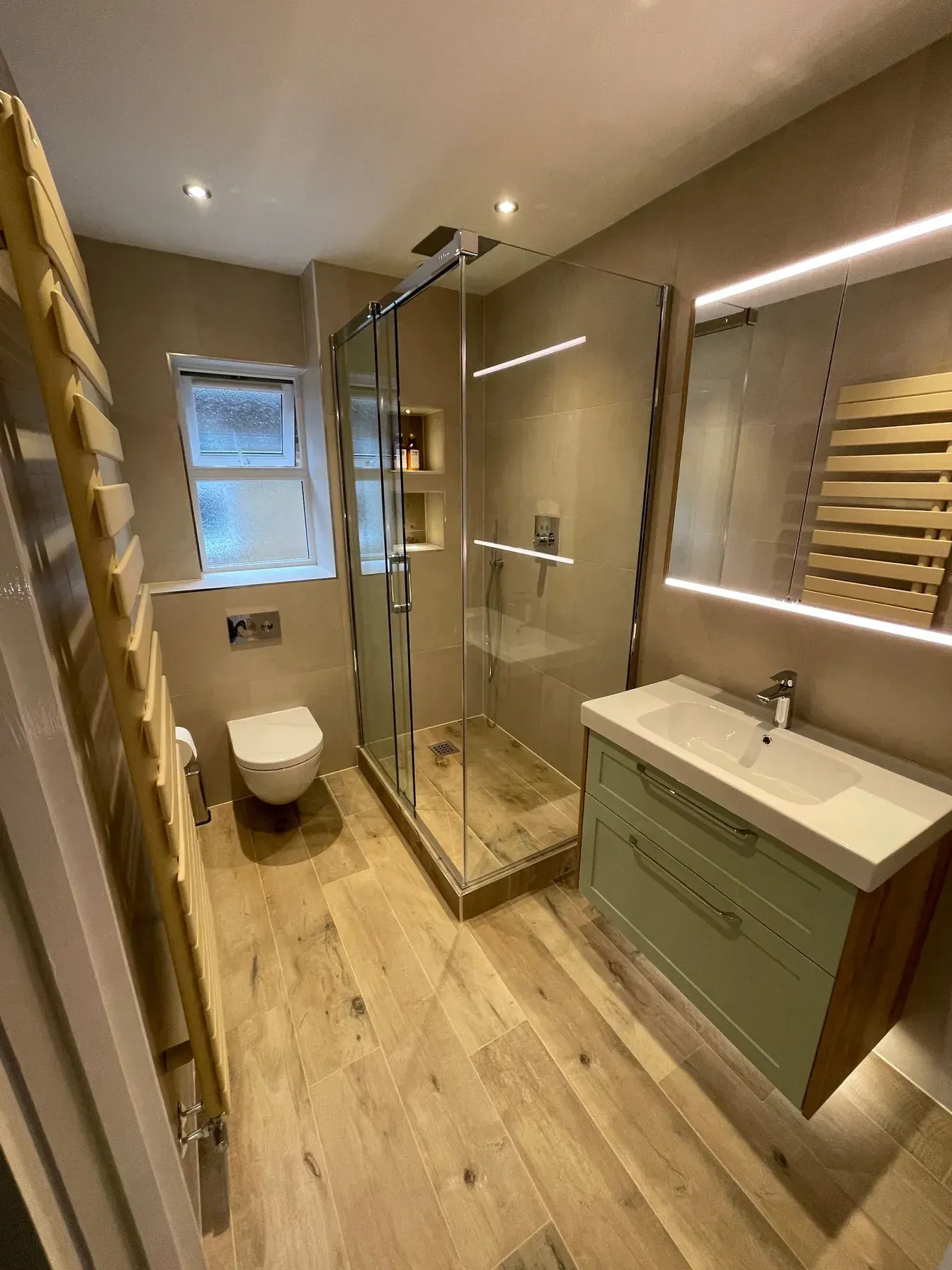 A modern, wetwall style bathroom with towel radiators designed and fitted by Options Bath and Tile Studio in Berkshire.