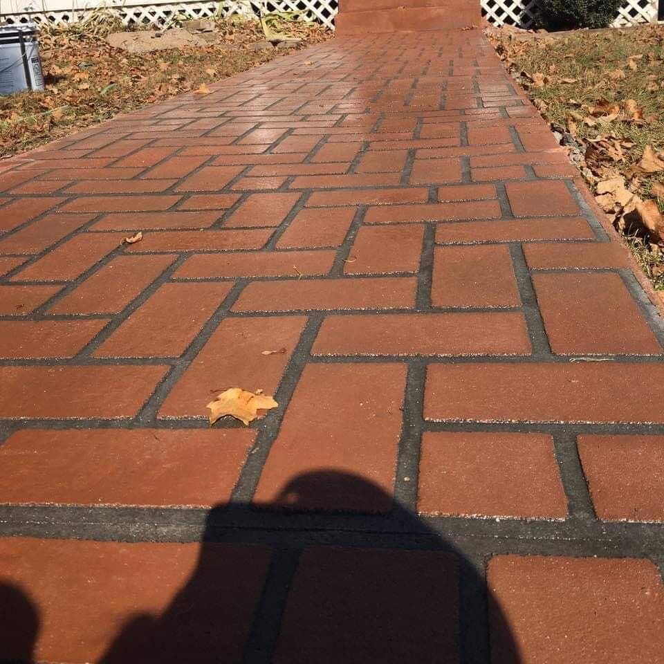 Brick sidewalk path with a leaf and strong shadow in sunlight