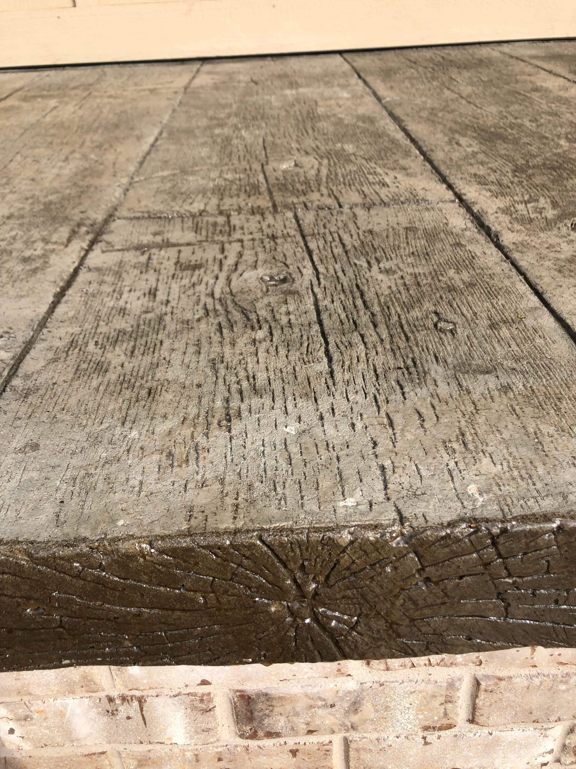 Close-up of a weathered concrete step with cracks and dark stains, viewed from above.