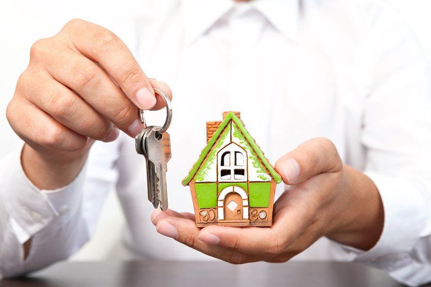 Woman holding model of a house and keys