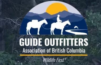 Guide Outfitters Association of British Columbia logo with mountains, sun, deer, hunter on horseback, and river