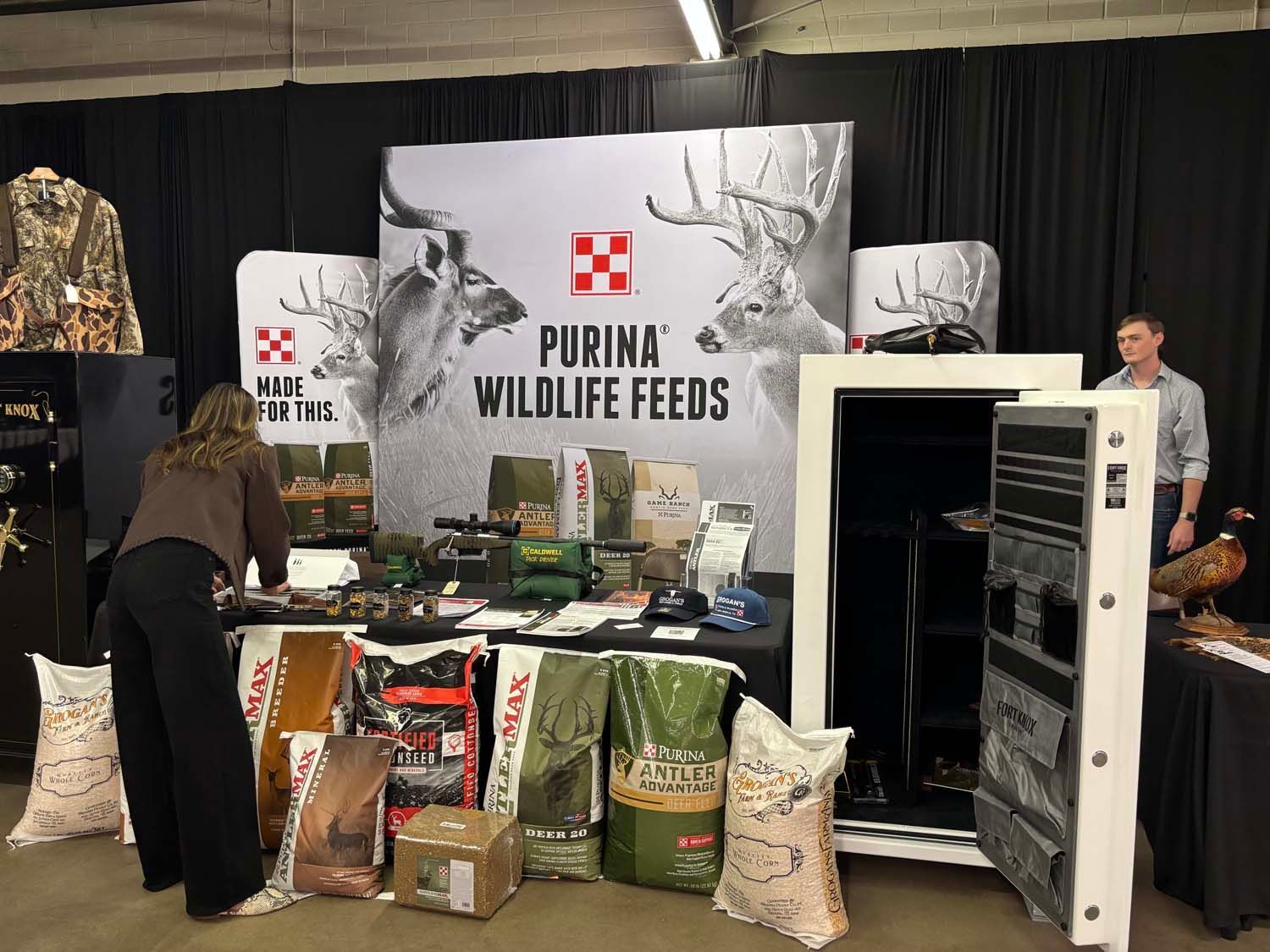 Trade show booth for Purina Wildlife Feeds with displays of feed bags and an open freezer case.