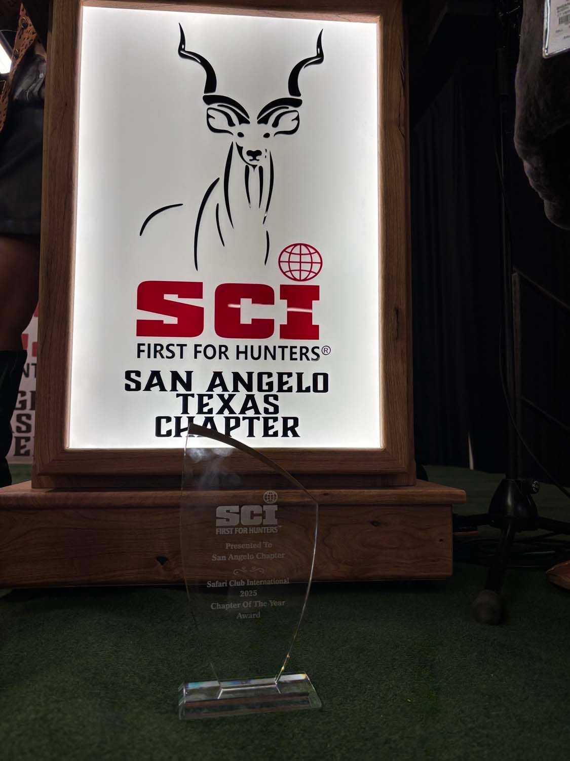 SIK banner for the San Angelo Texas chapter, with a horned figure logo on a lit sign