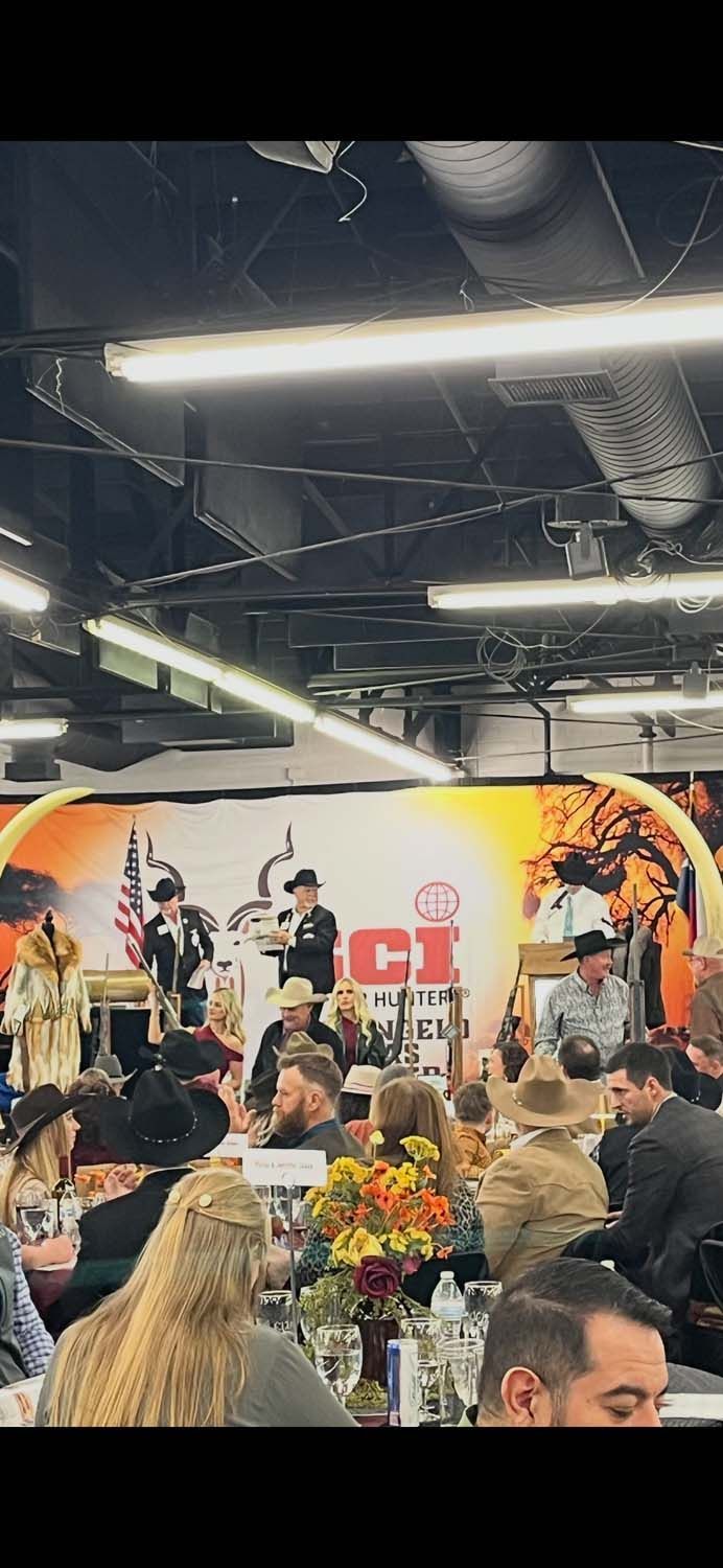 Crowded indoor concert with a band performing on a lit stage and audience in the foreground