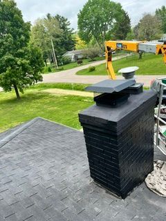 Rooftop view with black chimney vent and yellow crane over a green suburban yard