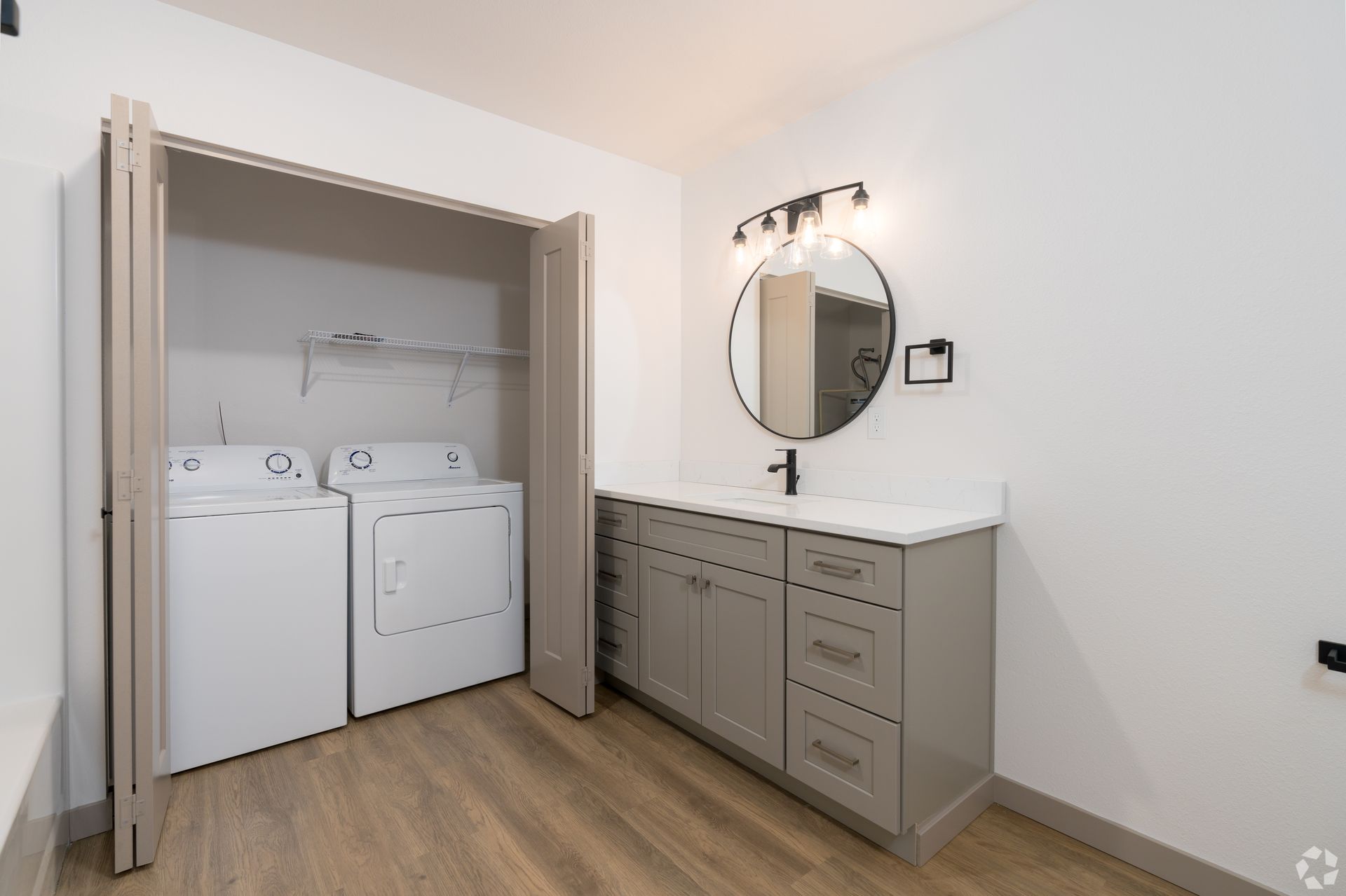 A laundry room with a washer and dryer and a sink.