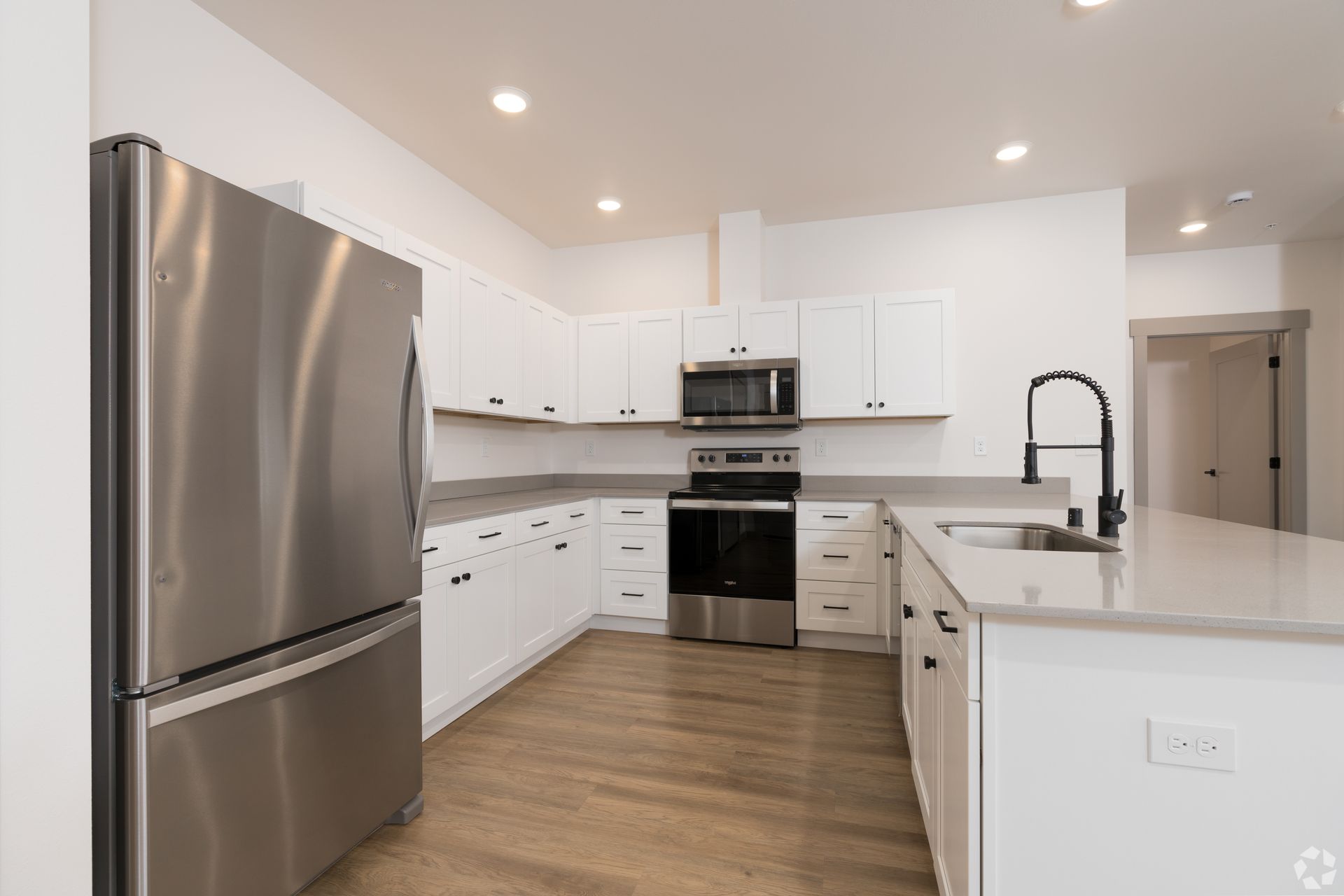 A kitchen with stainless steel appliances and white cabinets.