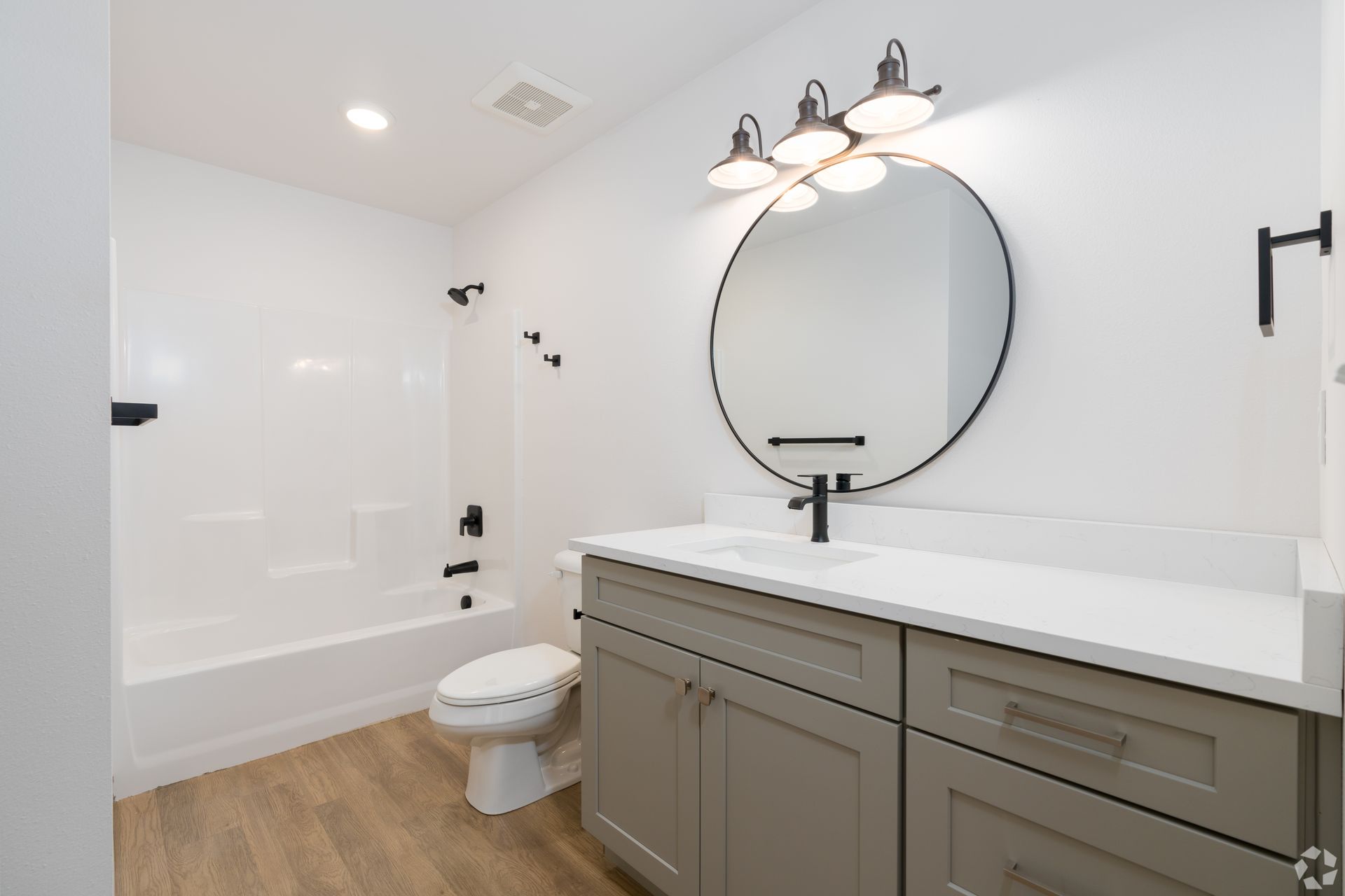 A bathroom with a toilet , sink , and mirror.