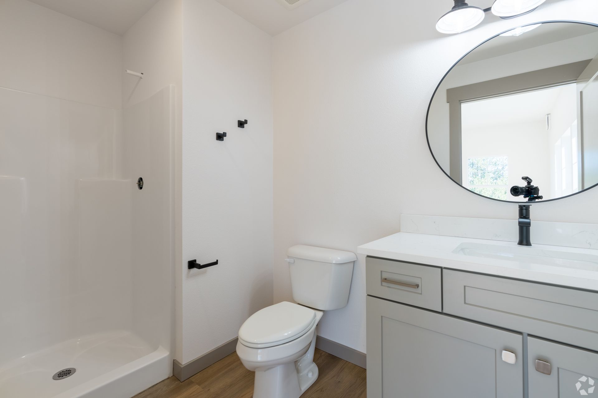 A bathroom with a toilet , sink , and shower.