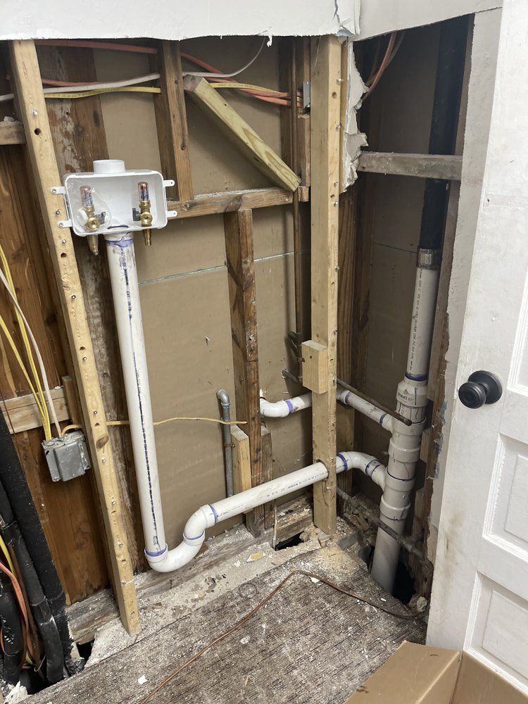 A bathroom with a hole in the wall and pipes coming out of it.