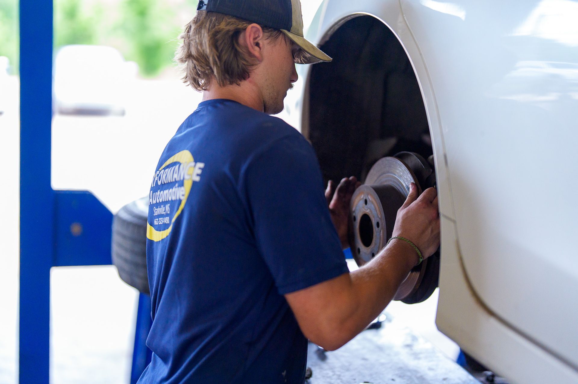 Technician performing brake inspection in service bay