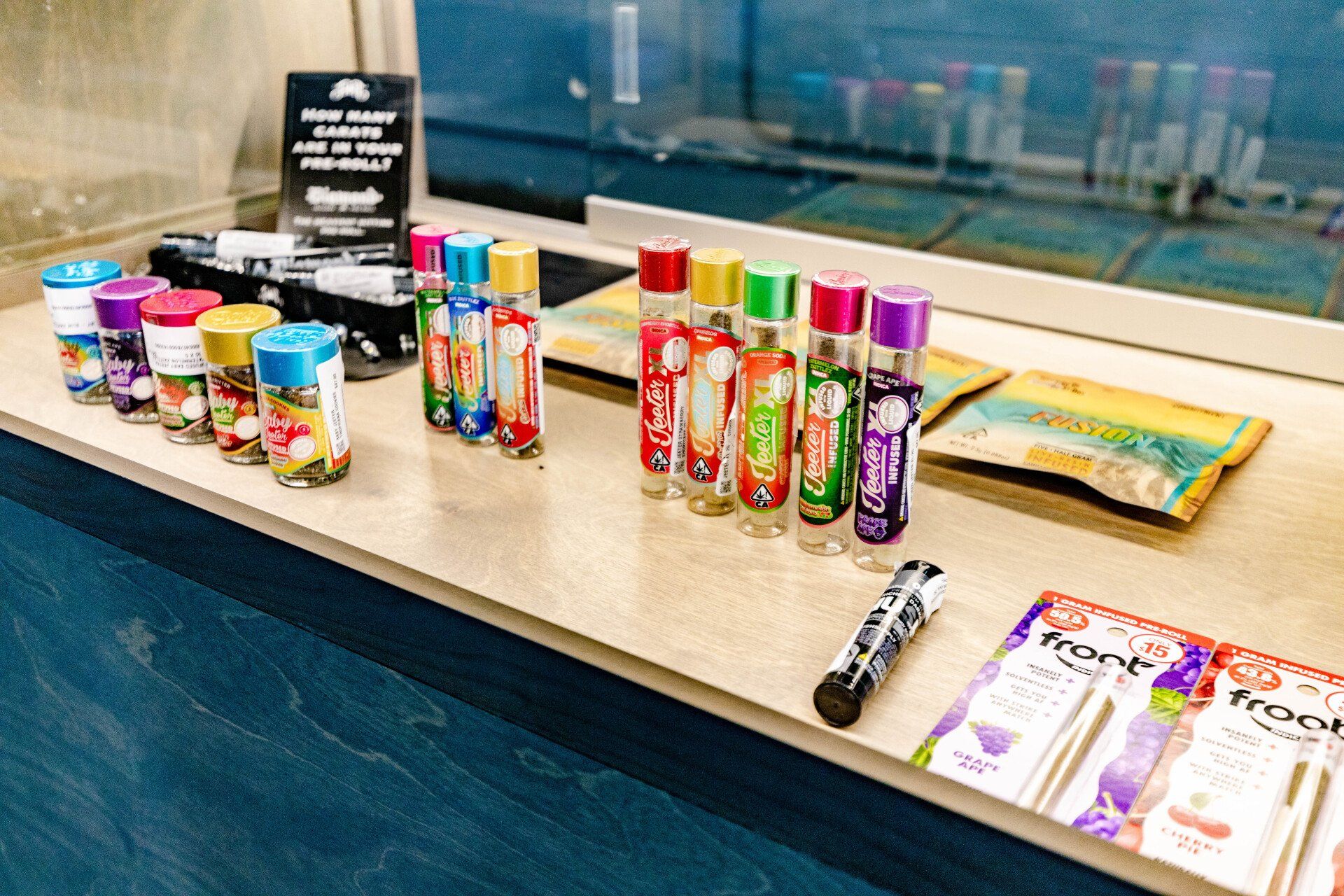 Display case with various vape pens in colorful packaging.