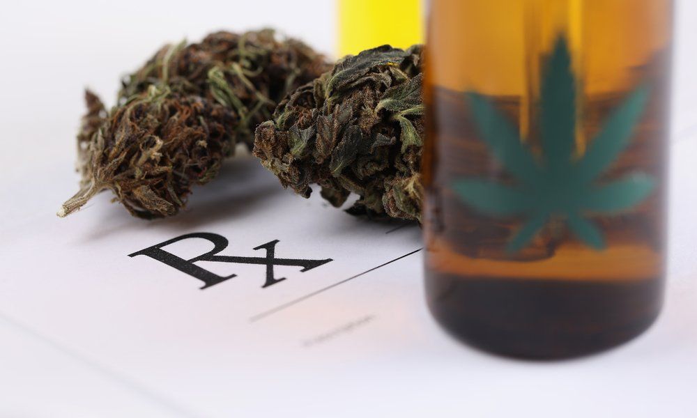 Cannabis buds next to a prescription with the letters