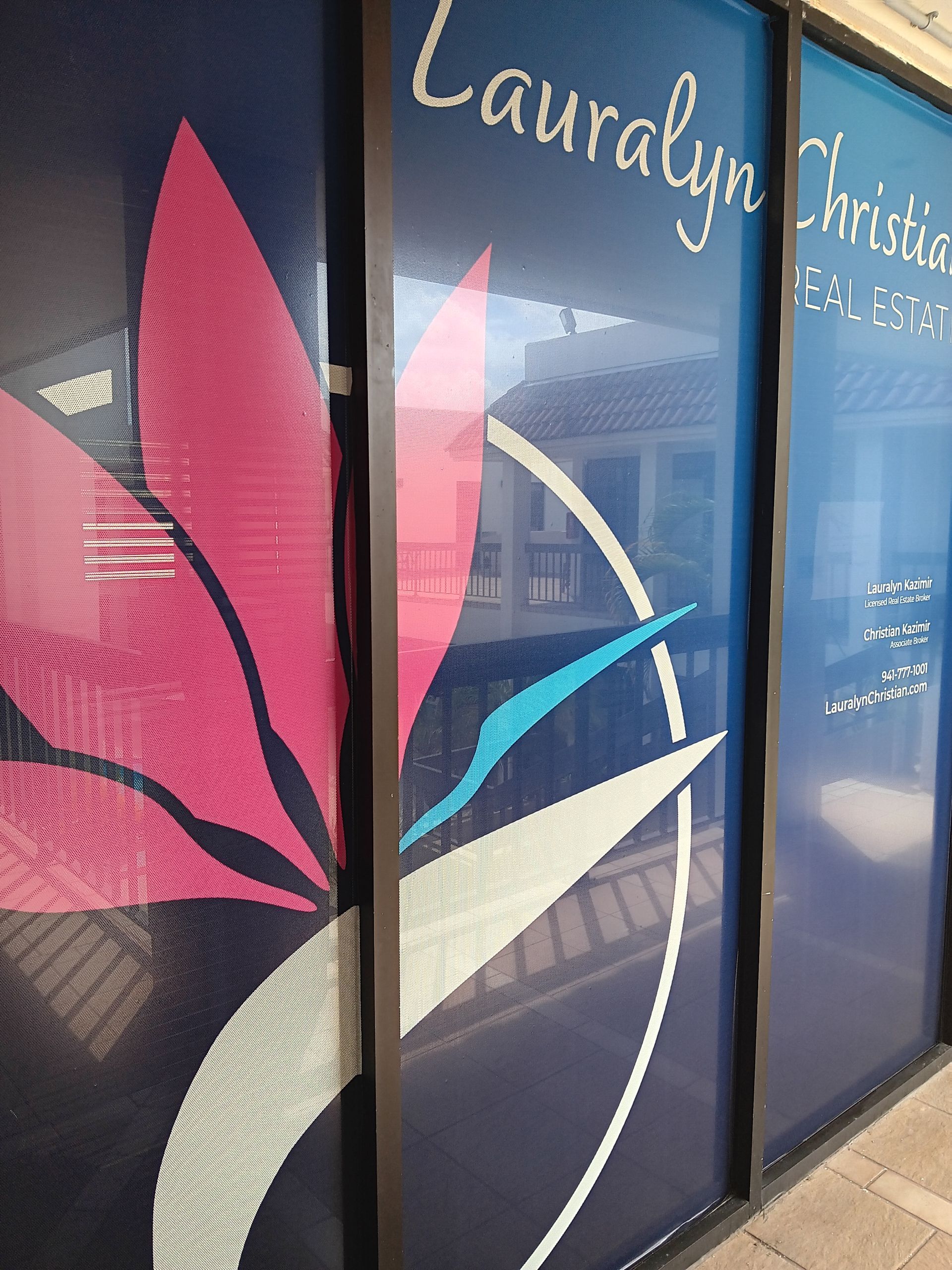 Window decals with a stylized flower on a blue background; text reads