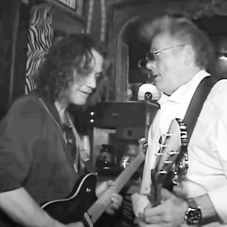 Eddie Van Halen playing guitar with Leslie West in a black and white photo
