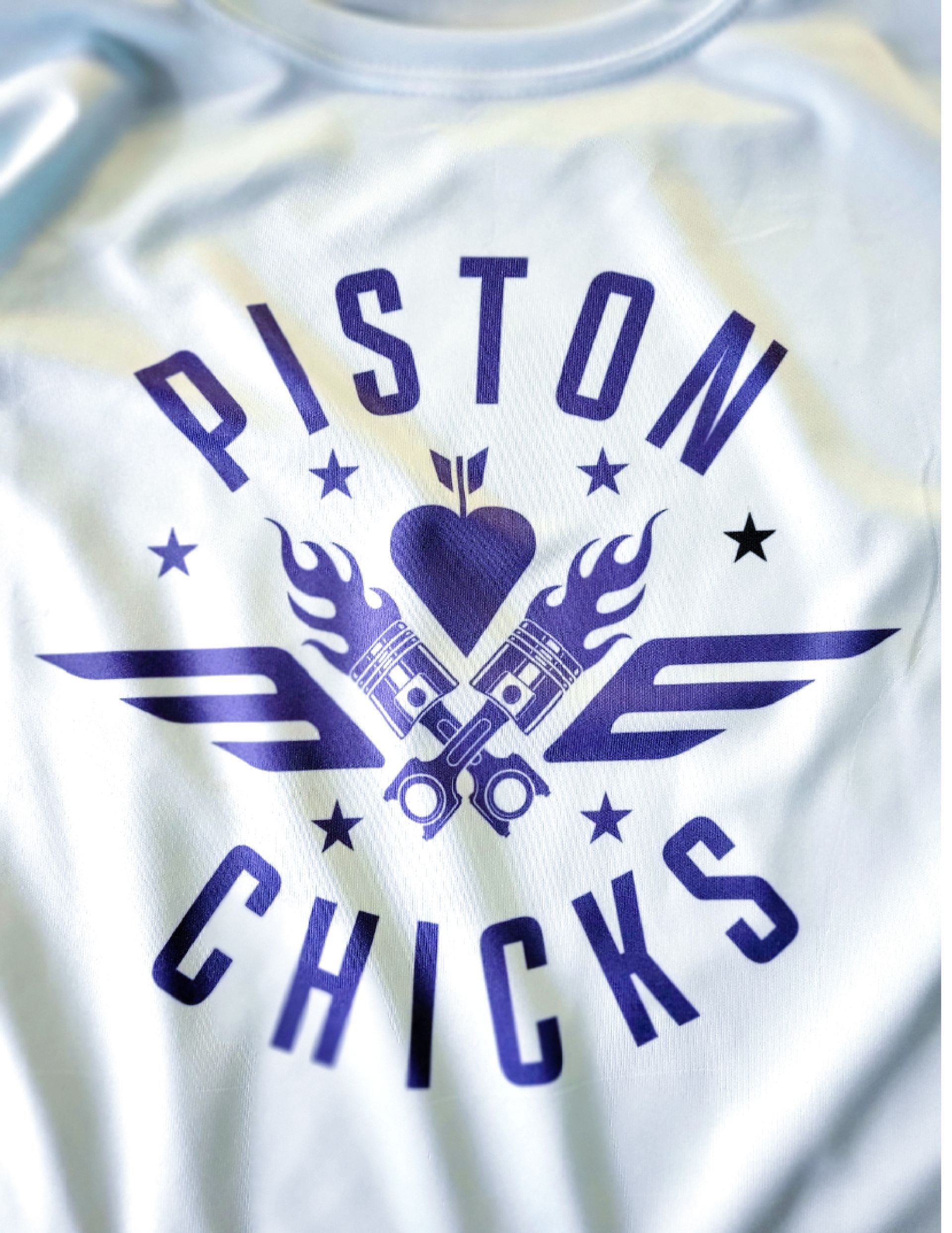 White t-shirt with purple text and graphic. Features