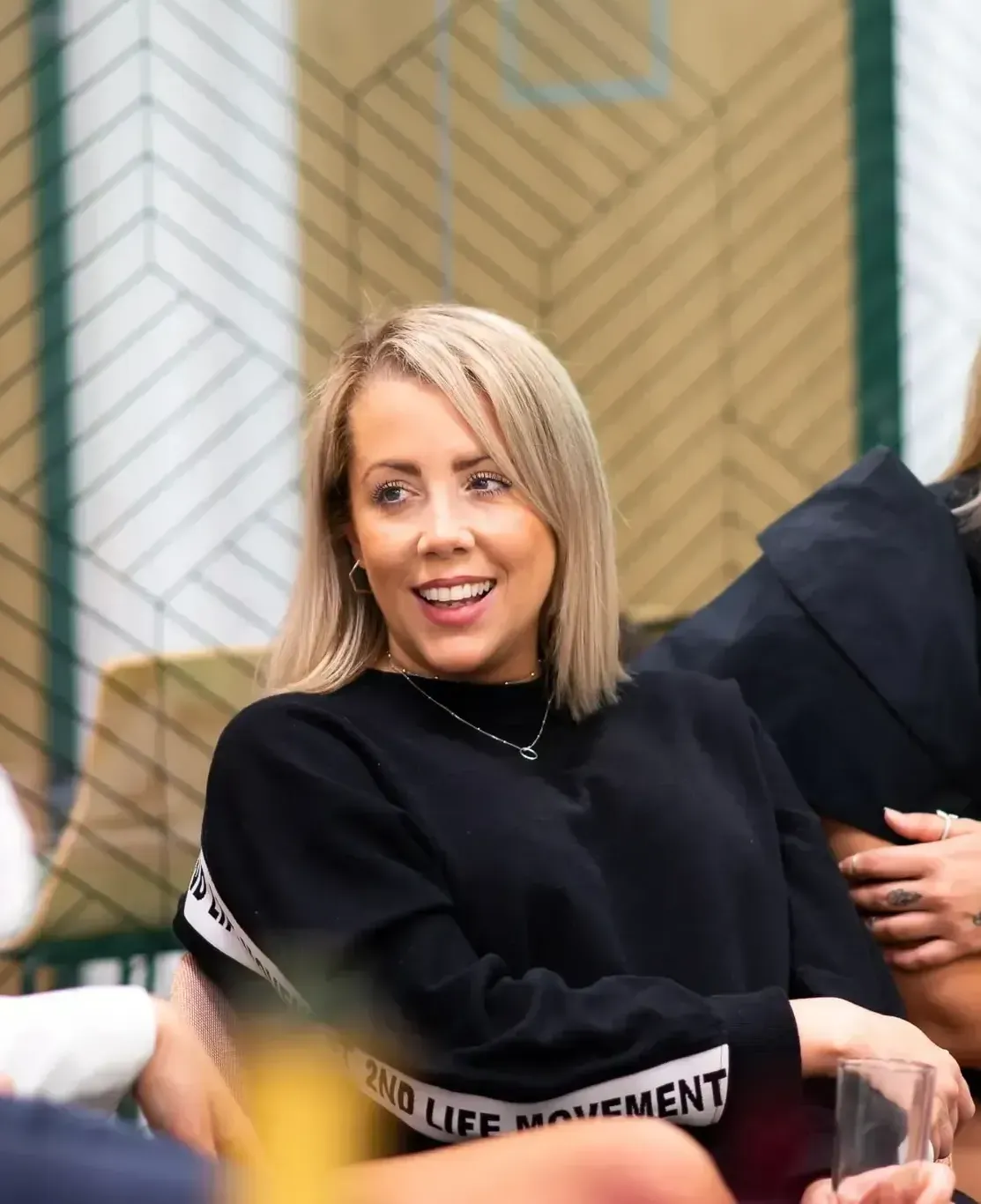 A woman wearing a black sweater with the word movement on it