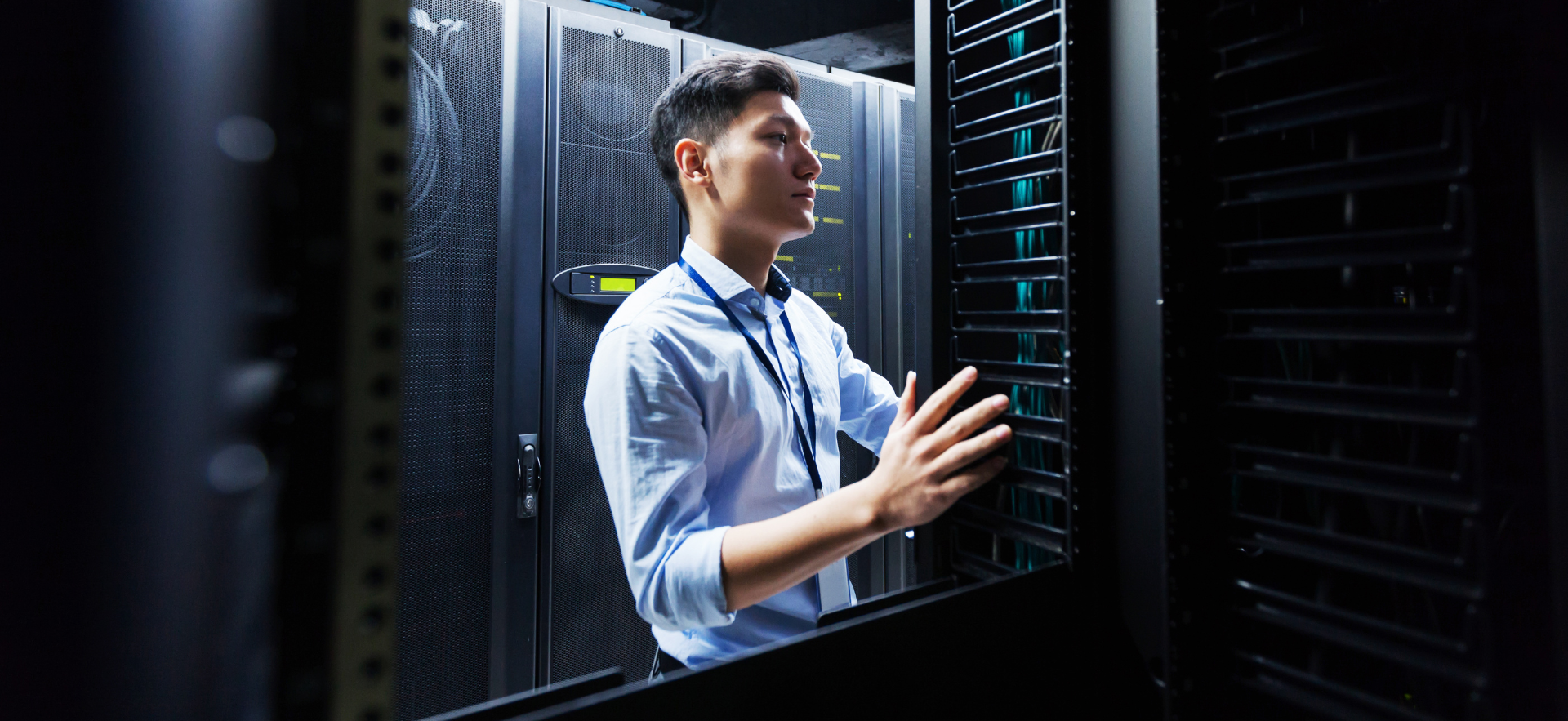 A man is working on a server in a data center.