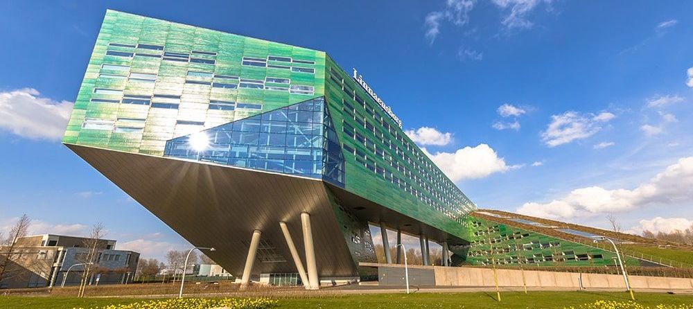 A large green building with a blue sky in the background.