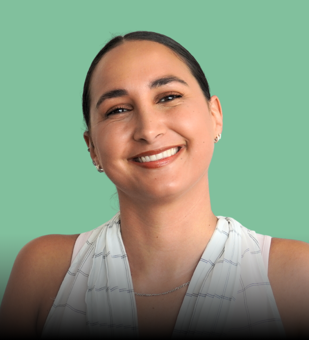 A woman is smiling for the camera while wearing a green shirt.