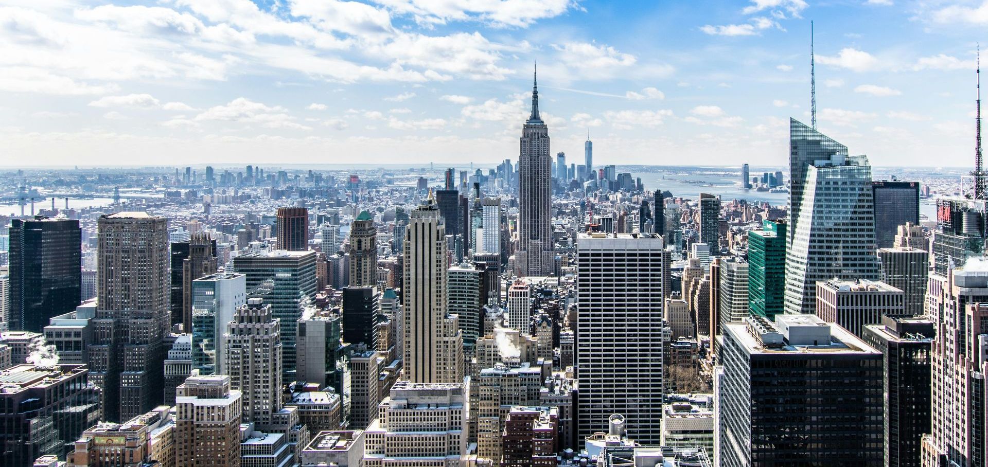An aerial view of the skyline of new york city on a sunny day.