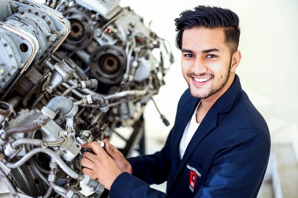 A man in a suit is working on a large engine.