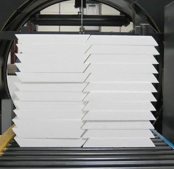 A stack of white boxes are sitting on a conveyor belt