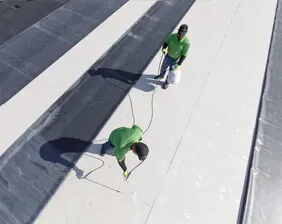 A couple of men are working on a roof.