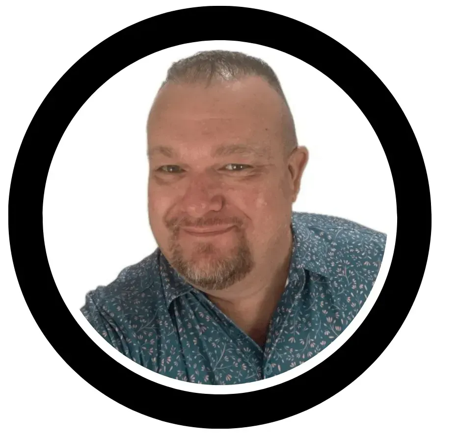A man with a beard is smiling in a circle on a white background.