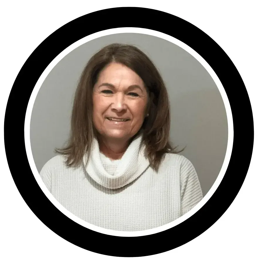 A woman in a white sweater is smiling in a black circle.