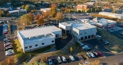 An aerial view of a large building with cars parked in front of it.